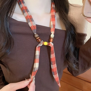 Detailed view of bohemian fabric scarf necklace with wooden beads and yellow resin accent