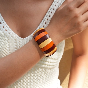 Detail of wooden beaded bracelet with geometric multicolor wood blocks on model wrist