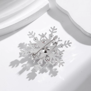 Silver snowflake brooch with rhinestones showing the pin back and metal base structure