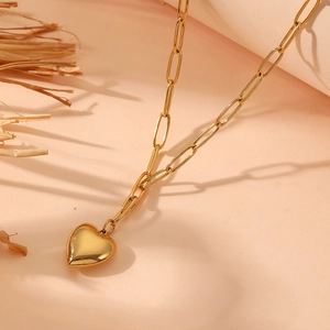 Detailed view of a gold heart pendant necklace featuring a modern paperclip link chain