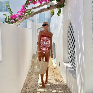 Détail d'un maillot de bain une pièce à motif carrelage rouge et blanc avec sac en paille