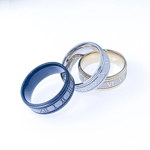 Detail view of interlocking stainless steel rings in black, gold and silver with Roman numerals