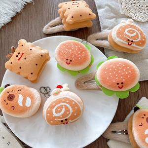 Detailed close-up of cute plush food-shaped hair clips and keychains on a tray