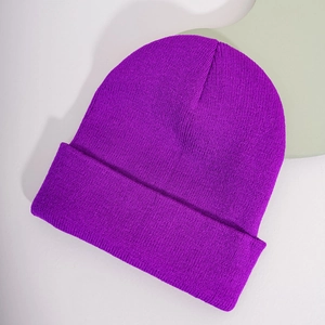 Close-up of a purple knitted beanie showing fine flat stitch texture and wide cuff design