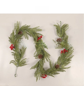 Detailed view of Christmas garland with pine branches, red berries and natural cones