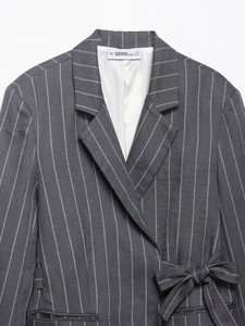 Close-up of gray striped blazer lapel showing woven texture and BBWM WOMAN brand label