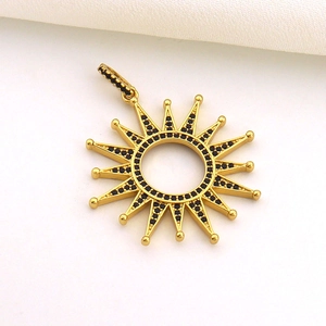 Macro shot of sun pendant with gold plating and embedded black cubic zirconia stones