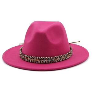 Detail of rose red fedora hat featuring a vibrant bohemian rainbow woven band and wide brim