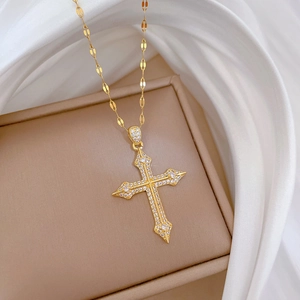 Detailed close-up of a luxury gold cross necklace with micro-pave cubic zirconia inlay
