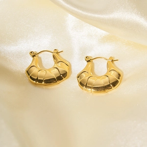 Dettaglio di orecchini a cerchio spessi placcati oro 18K su elegante raso crema