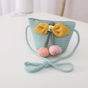 Blue straw crossbody bag for children featuring a yellow bow and pink cherry charms