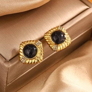 Macro detail of retro square gold stud earrings with marble stone and white diamonds