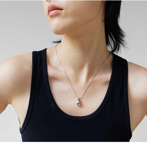 Poliertes silbernes Tropfenanhänger-Halsband mit Schlangenkette am Hals eines Models