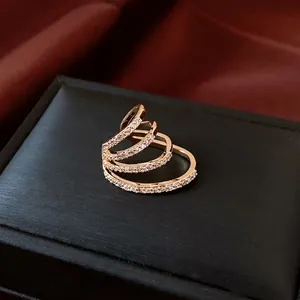Luxurious multi-layer gold plated ring featuring sparkling zircon pavé on a silk background