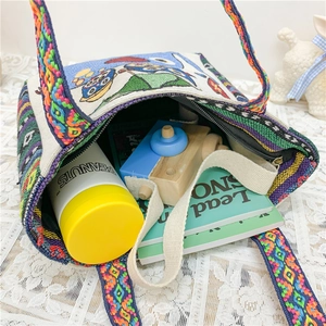 Ethnic style embroidered canvas tote bag with woven handles showing large interior capacity