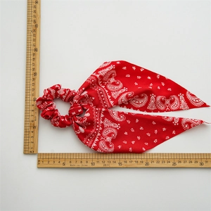 Red Paisley bandana hair scrunchie with long ribbon tails shown against measurement rulers