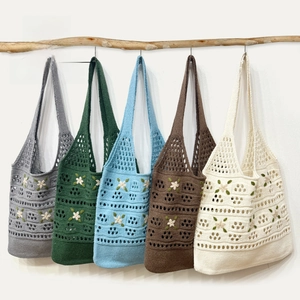 Detailed view of hand-knit crochet tote bags with flower embroidery in five colors