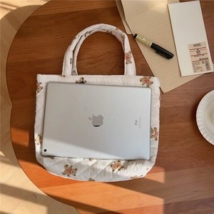Quilted tote bag with cute bear print showing capacity for an iPad on a wooden table
