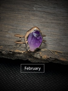 Macro shot of raw February birthstone amethyst set on a vintage bronze adjustable ring
