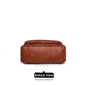 Detail view of the rectangular bottom and reinforced stitching on a brown PU leather bag