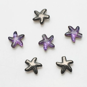 Detailed view of glass starfish pendants in purple gradient and silver black textures