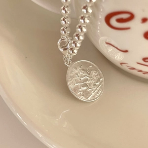 Detail of 925 silver beaded bracelet featuring a vintage 1901 coin pendant relief