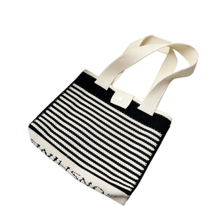 Striped knit tote bag with beige straps and SNOW IS NICE lettering on white background