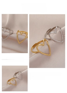Detail of gold and silver heart-shaped rings with hammered texture and open design