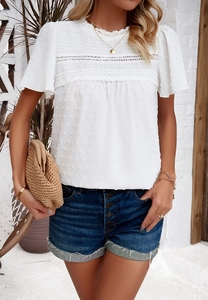 Detail of white textured short sleeve top with lace trim and smocked neckline details