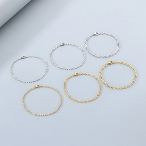 Detailed view of six gold and silver stainless steel chain bracelets in various link styles
