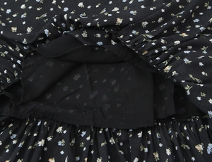 Close-up of floral print dress featuring black lining and fine pleated craftsmanship