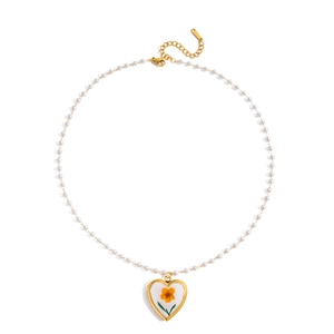 Détail du collier en acier inoxydable 18K avec pendentif cœur et fleurs séchées oranges