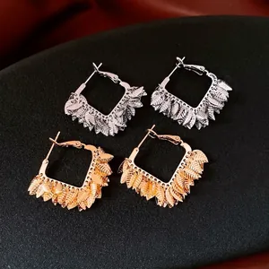18K gold and silver plated hoop earrings with cascading metal leaf clusters on black surface