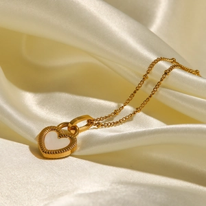 Détail du pendentif en forme de cœur avec nacre sur un fond en soie luxueux