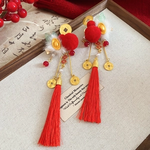 Detail of New Year hair clips with red pompoms, lucky koi tassels and golden accents