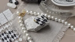 Detail of embossed harlequin and marble nail art stickers with pearl accents on stones