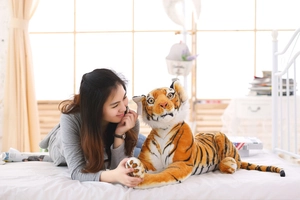 Detailed view of a large lifelike tiger plush skin showing realistic stripes and facial features