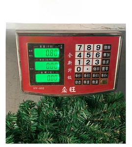 Detailed view of 60cm green artificial Christmas tree showing a weight of 0.80kg on a scale