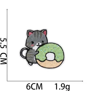 Detail of embroidered gray cat and donut patch showing 6cm x 5.5cm dimensions