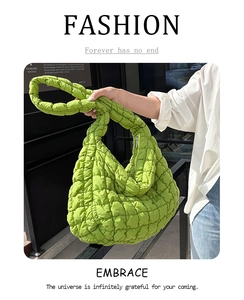 Macro shot of bright green quilted puffy bag texture and nylon fabric stitching details