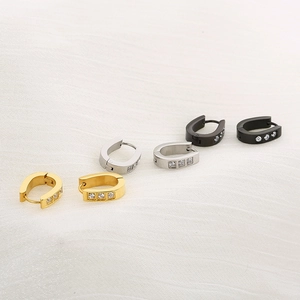 Macro shot of U-shaped stainless steel earrings in gold, silver, and black with zircon