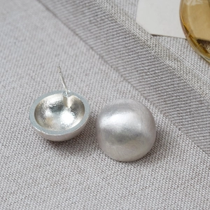 Detailed close-up of matte silver hemispherical studs with brushed metal texture