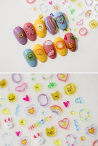 Detail showing 3D embossed nail stickers with rainbow, bear, and heart patterns