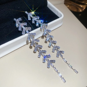 Gros plan de boucles d'oreilles pendantes argentées avec zircons cubiques géométriques