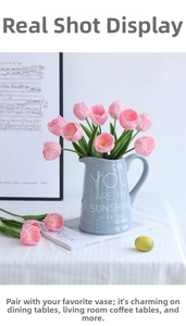 Pink artificial tulip bouquet in a light blue ceramic pitcher vase with vintage props