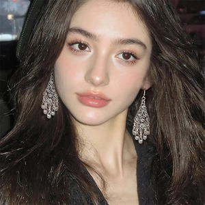 Bohemian hollow flower teardrop earrings in antique silver finish worn by a model