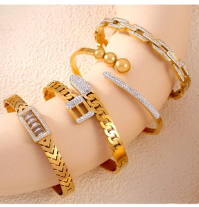 Detail of four gold-plated titanium steel bracelets with crystals and chain links