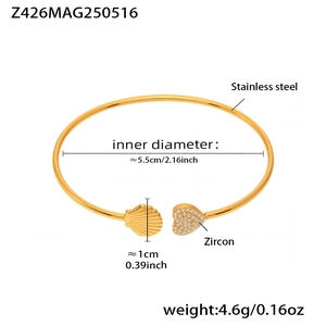 Detail of 18k gold plated stainless steel cuff with shell charm and zircon heart