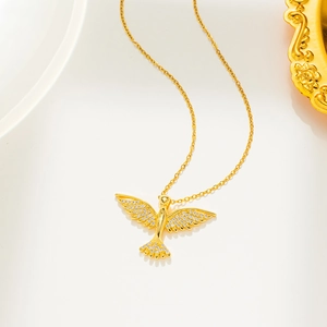 Macro shot of a golden phoenix necklace pendant with sparkling rhinestones on white