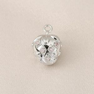 Macro view of a silver strawberry pendant featuring sparkling pink zircon inlays and detail